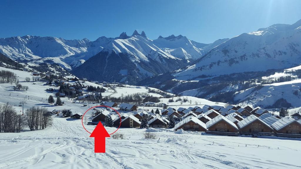 a village in the snow with a red arrow at L'Alpage in La Chal