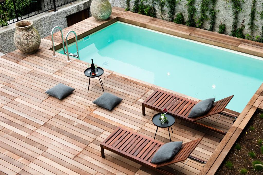 a swimming pool with two benches and a table and chairs at Stella Sky in Ljubljana