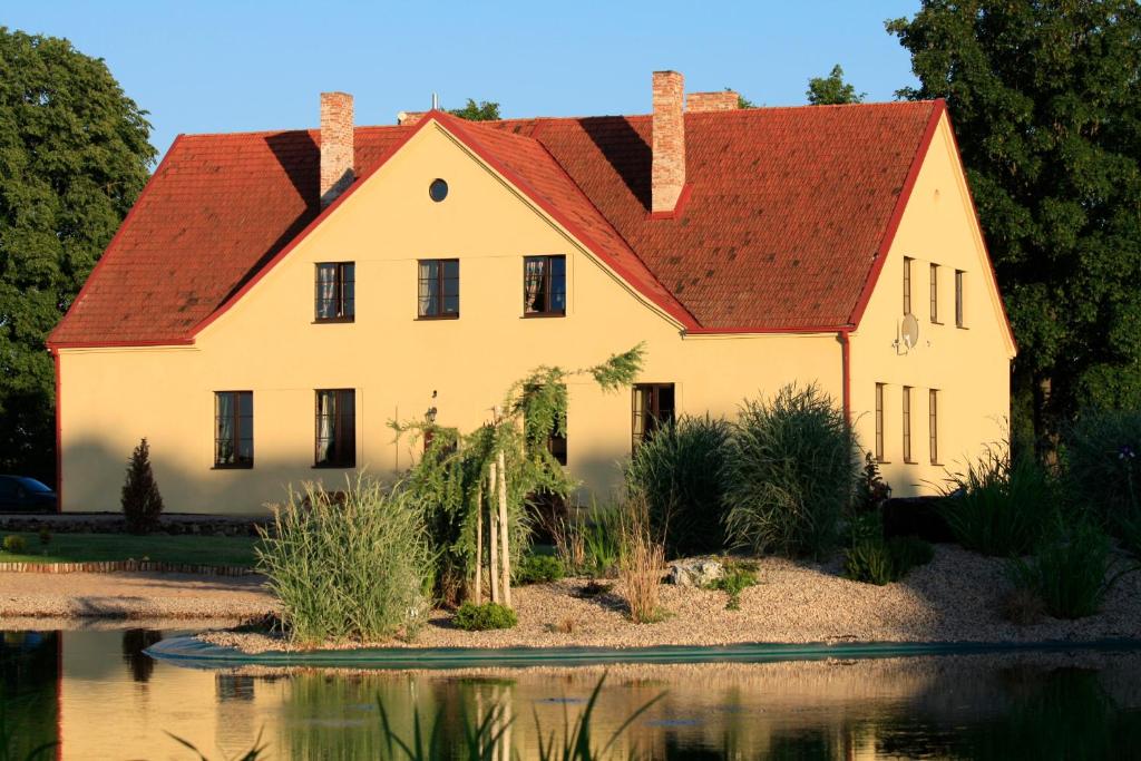 a large white house with a red roof at Akmenių Dvaras in Akmeniai
