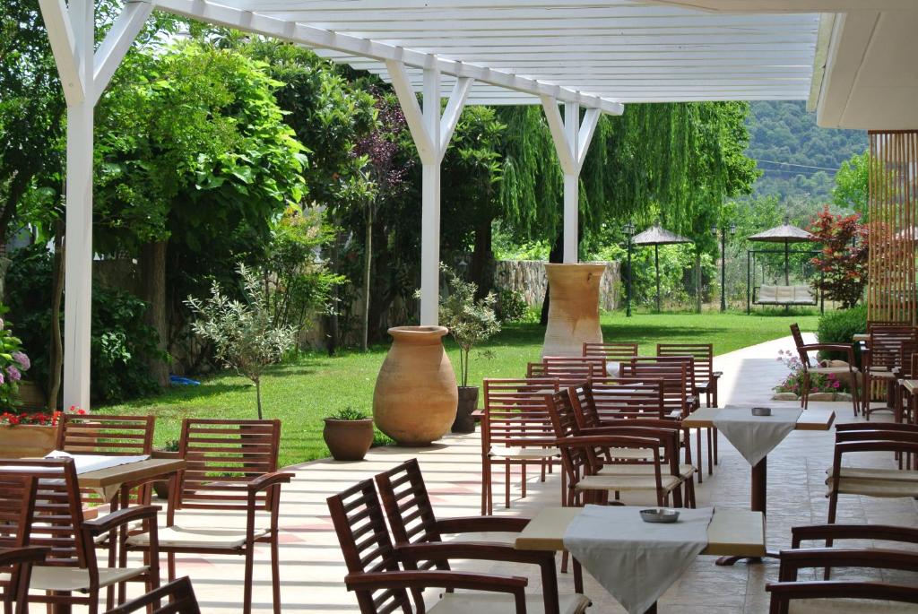 a group of tables and chairs under a white pergola at Milies in Stavros