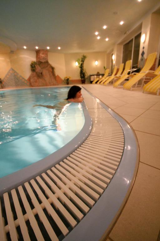 a woman in a swimming pool in a building at Hotel Styrolerhof in Steeg