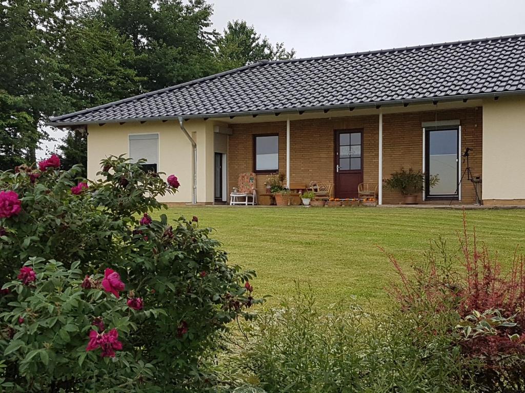 a house with a yard with pink flowers at Ferienwohnung Hof Theensen in Bad Münder am Deister