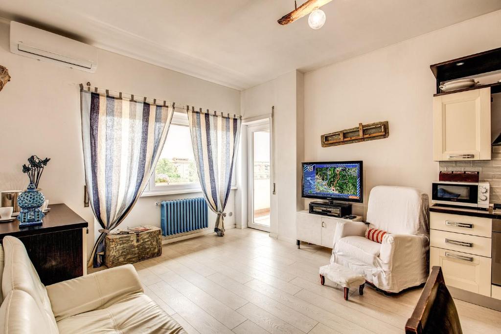 ein Wohnzimmer mit einem Sofa und einem TV in der Unterkunft Seaside Rome in Lido di Ostia