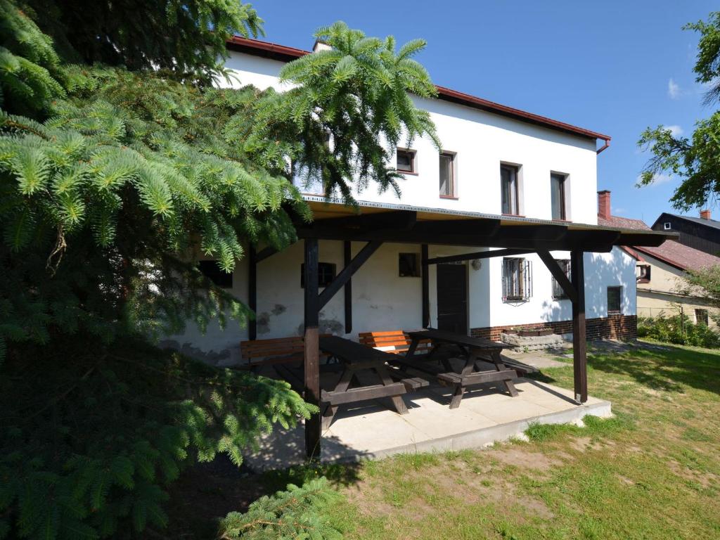 una casa blanca con una mesa de picnic delante de ella en Holiday home in Jiret n pod Jedlovou with sauna, en Jiřetín pod Jedlovou