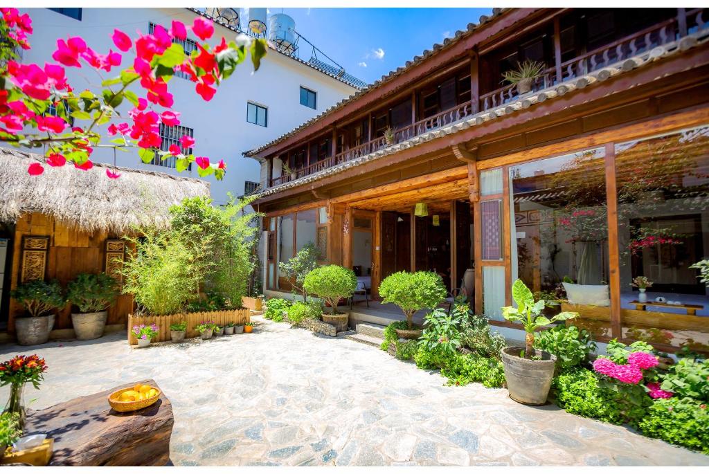 a courtyard of a building with flowers and plants at Log Cabin in Dali