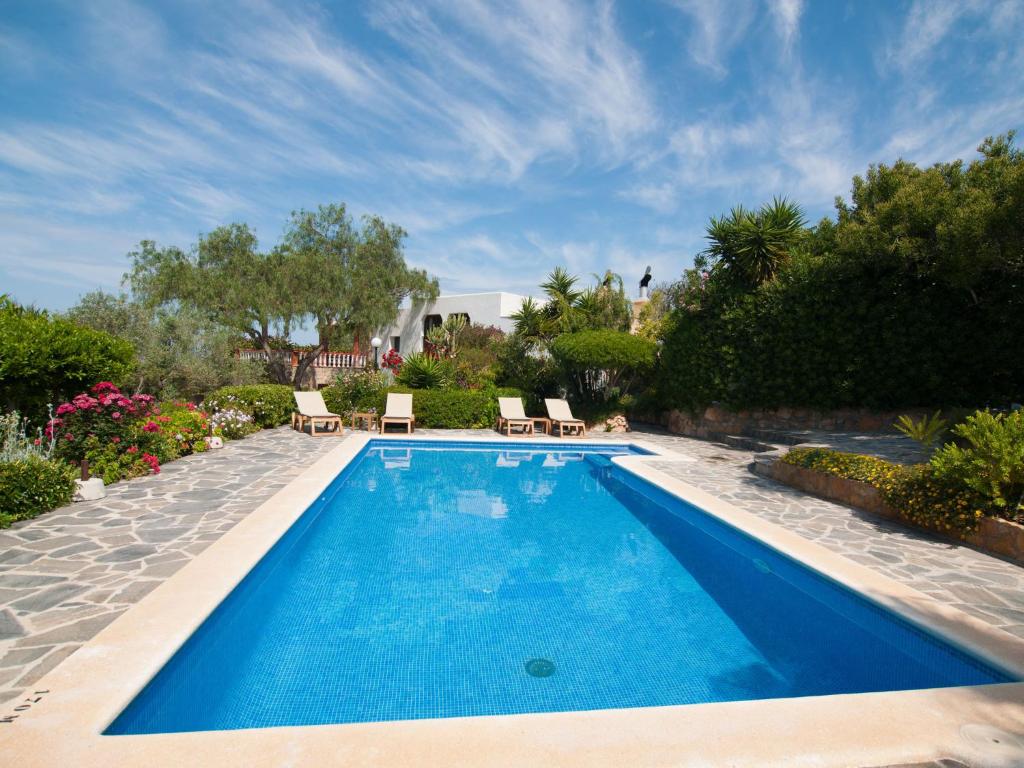 a swimming pool with blue water in a yard at Belvilla by OYO Can Jurat in Ses Paisses