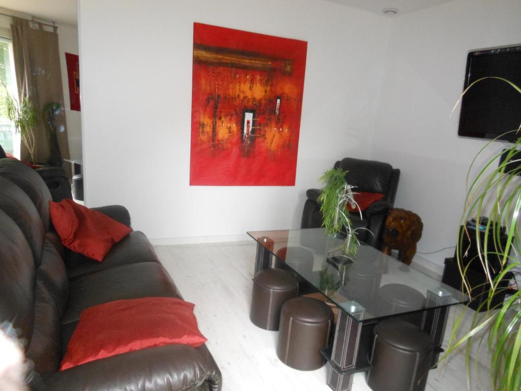 a living room with a couch and a glass table at Les Berges de l'Ô in Saint-Nicolas-de-Port