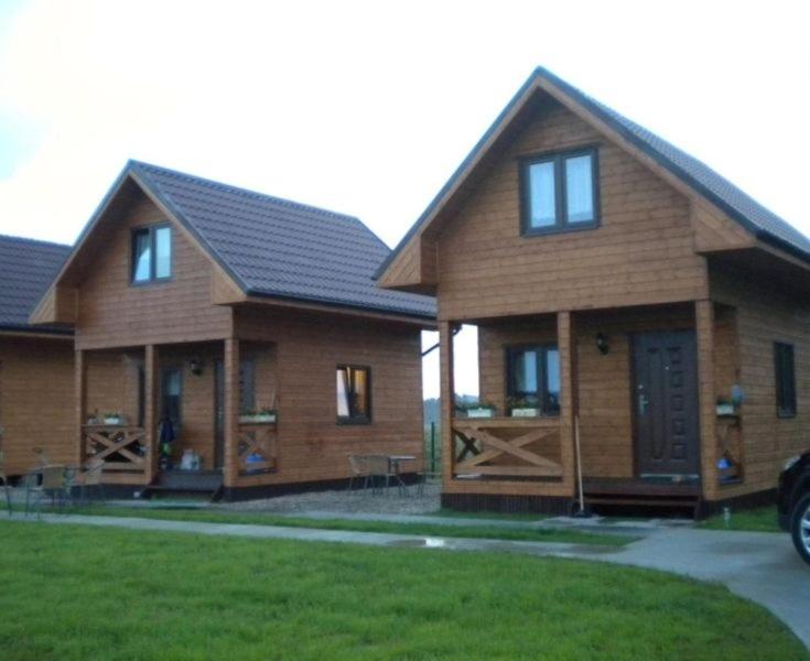 a large wooden house with windows and a yard at Domki letniskowe u Krzysia in Jastrzębia Góra