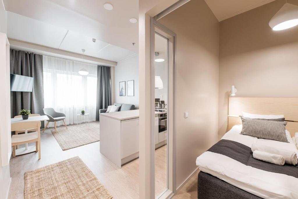 1 dormitorio con 1 cama extragrande y escritorio en Forenom Aparthotel Vantaa Tikkurila, en Vantaa