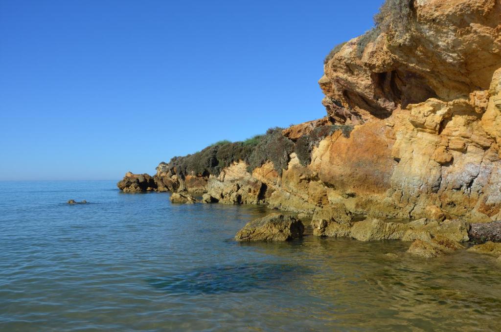 a large body of water next to a rocky shore at Rocca dei tramonti in Punta Braccetto