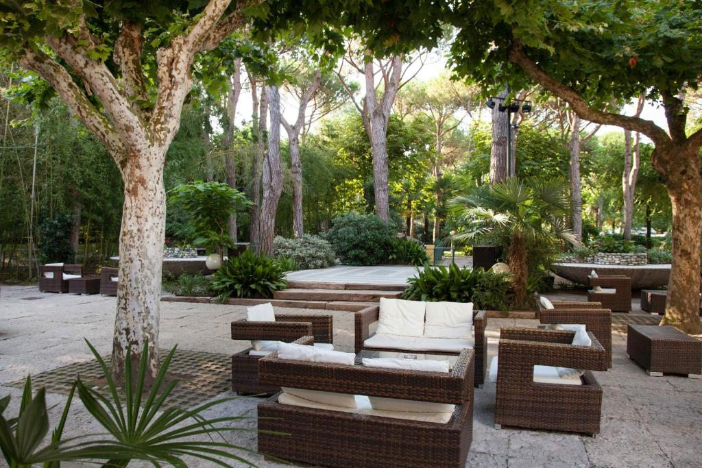 a patio with couches and tables and trees at Hotel Valdor in Cavallino-Treporti
