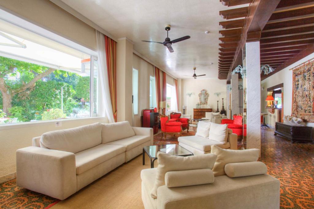 a living room with white couches and red chairs at Hotel Valdor in Cavallino-Treporti