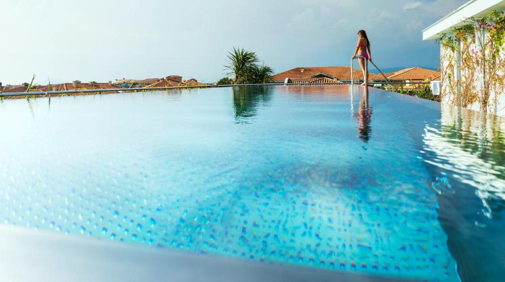 una mujer parada en el borde de una piscina en Villa Romana Fréjus, en Fréjus