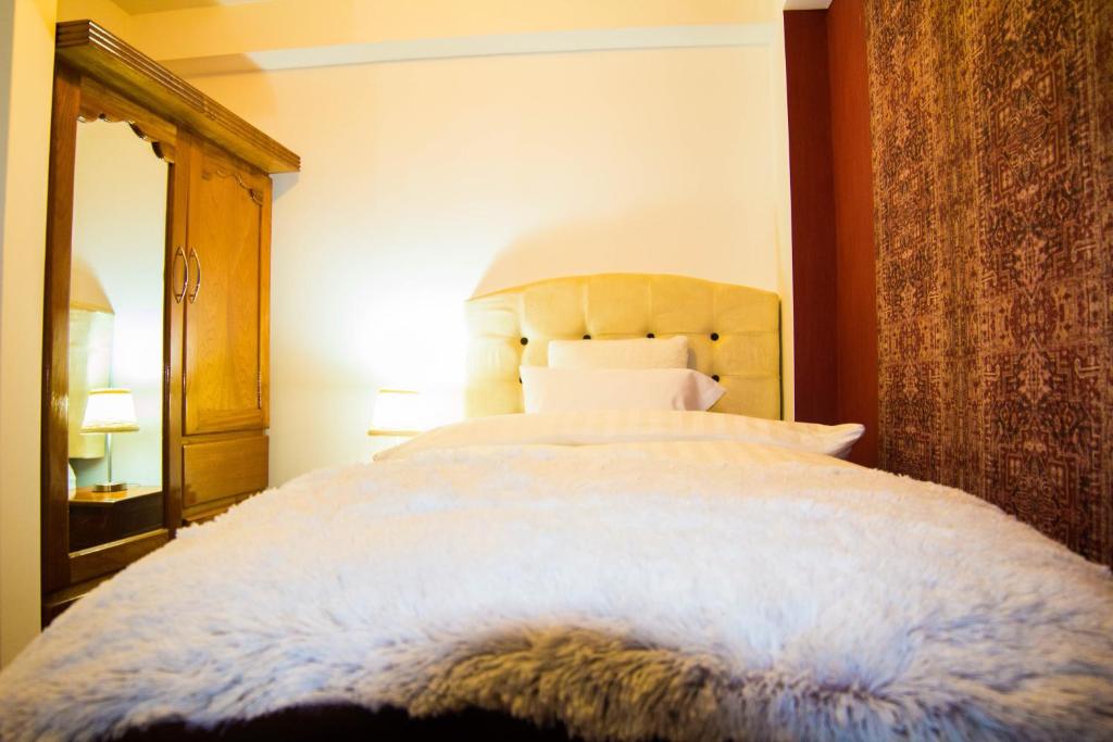een slaapkamer met een groot bed met een houten hoofdeinde bij Boutique Amaru Wasi in Cuzco