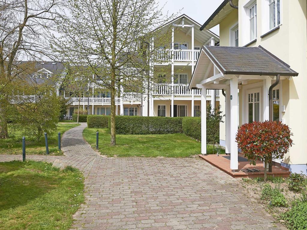 een wit huis met een stenen loopbrug ervoor bij Dünenpark Binz - WG202 mit Terrasse strandnah in Binz