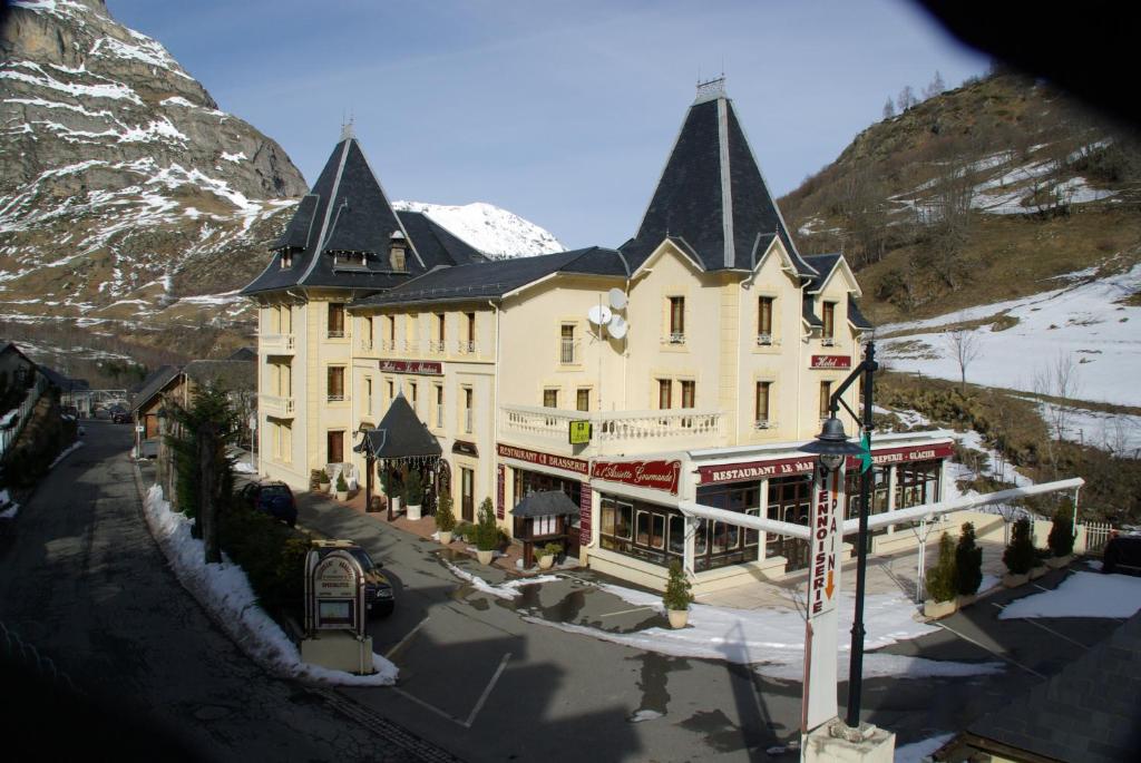 een groot wit gebouw met zwarte daken op een berg bij Le Marboré in Gavarnie