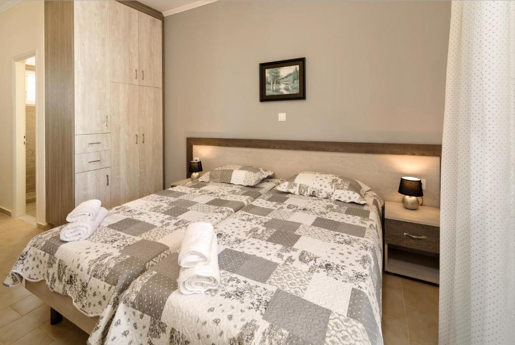 a bedroom with a large bed with towels on it at Morfeas Zante Apartments in Zakynthos Town