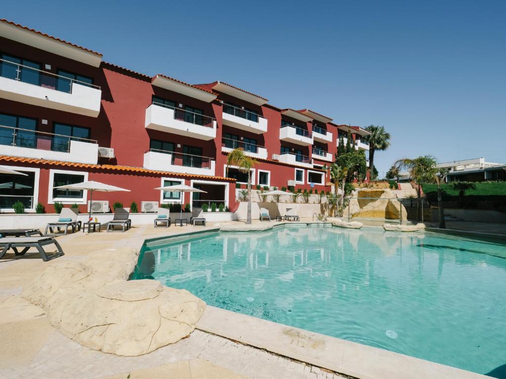 a large swimming pool in front of a building at Topazio Vibe Beach Hotel & Apartments - Adults Friendly in Albufeira