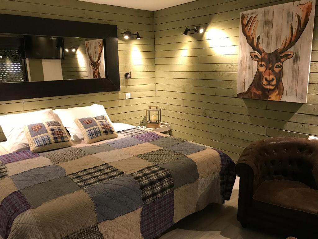 1 dormitorio con 1 cama y una foto de un ciervo en la pared en La tanière des ours, en Chaumont-sur-Tharonne