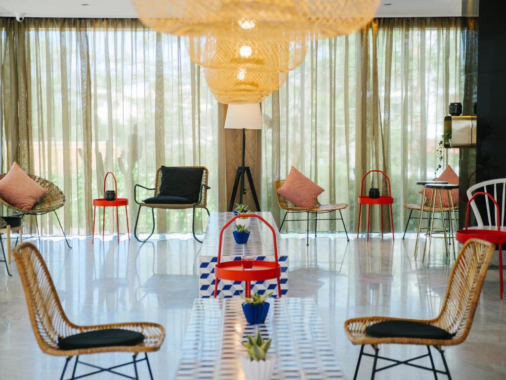 a room with chairs and tables and a chandelier at Topazio Vibe Beach Hotel & Apartments - Adults Friendly in Albufeira