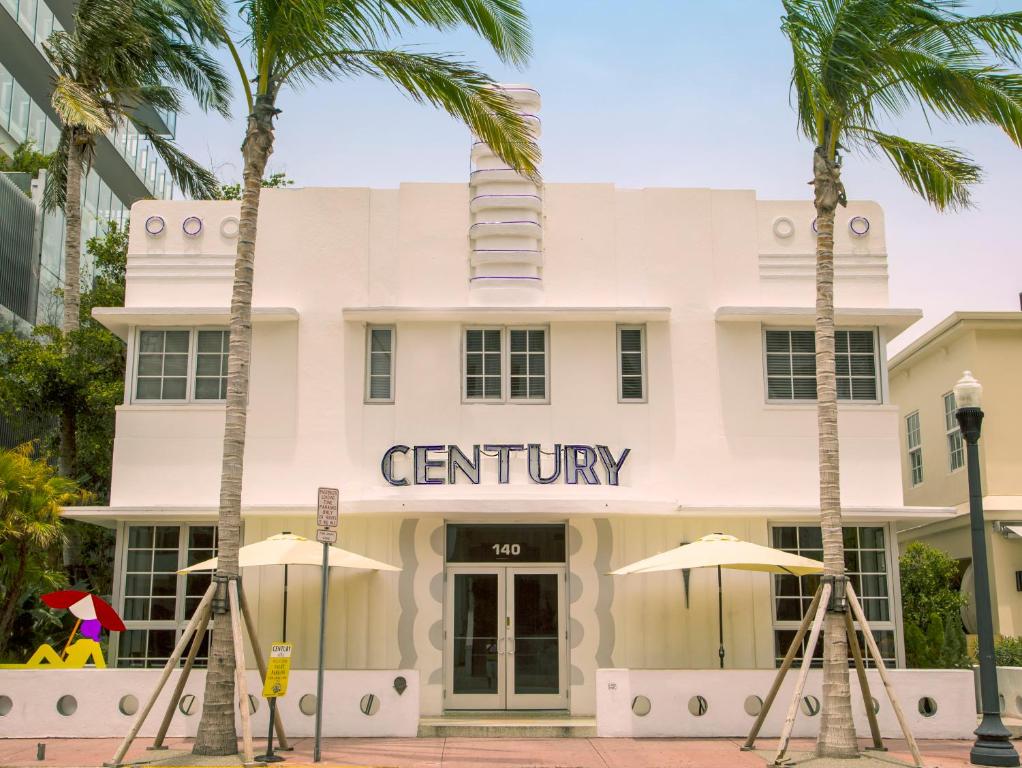 um edifício com palmeiras em frente em Century Hotel em Miami Beach