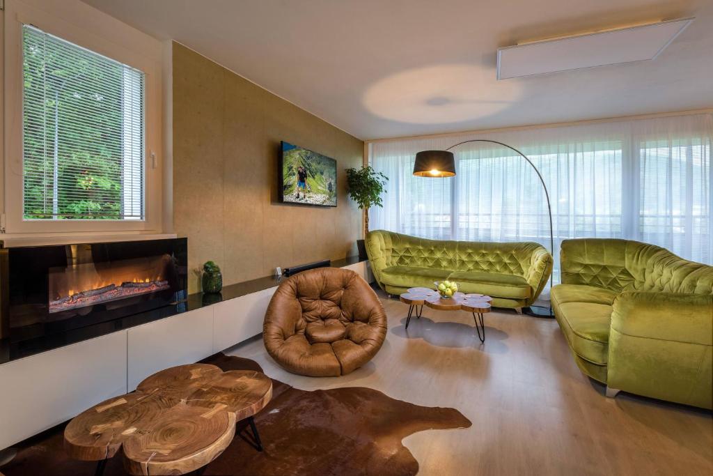a living room with green furniture and a fireplace at Apartmanica Triangel 103 in Donovaly