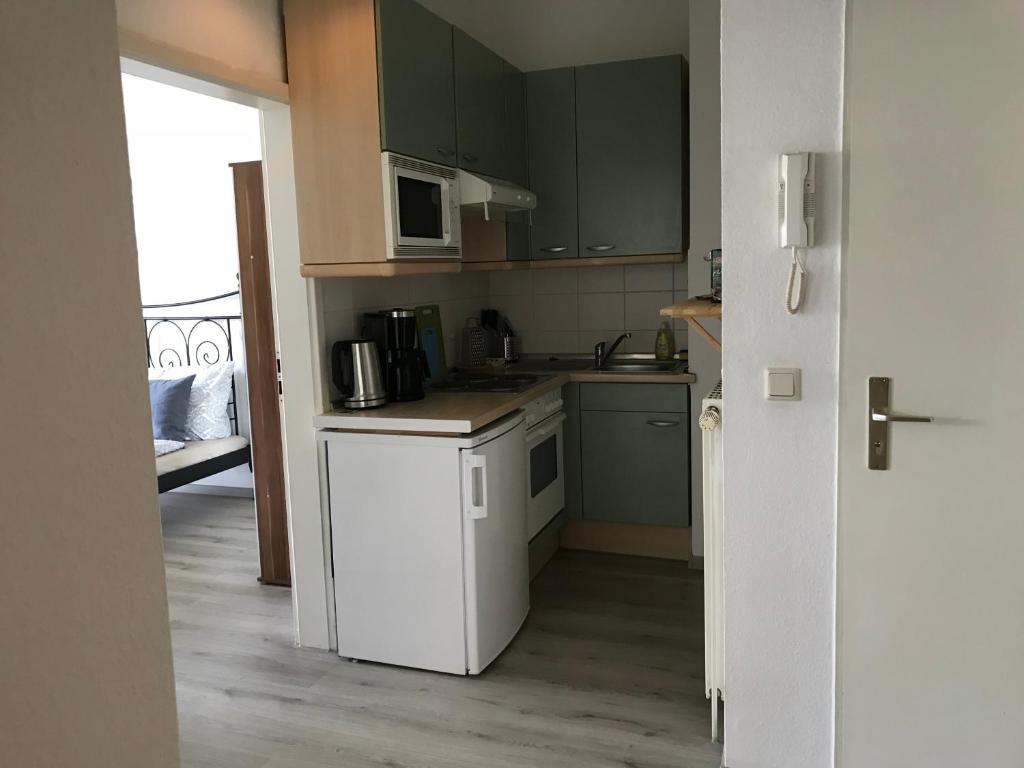 布萊梅的住宿－Apartment Hollergrund，厨房配有绿色橱柜和白色冰箱