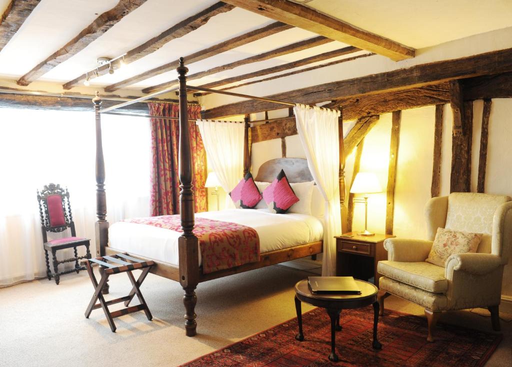 een slaapkamer met een hemelbed en een stoel bij House of Agnes in Canterbury