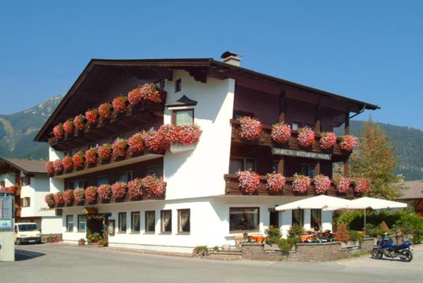 un edificio con cajas de flores en su lado en Sporthotel Pechtl, en Lermoos