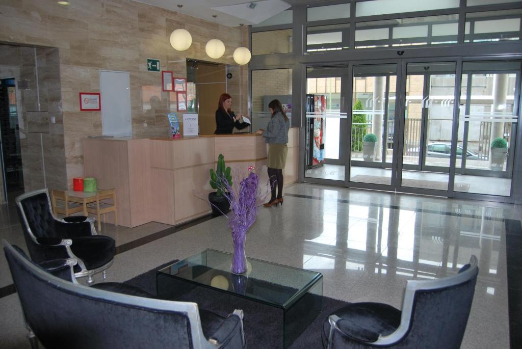 a woman standing at a counter in a lobby at Aparthotel Encasa in Madrid