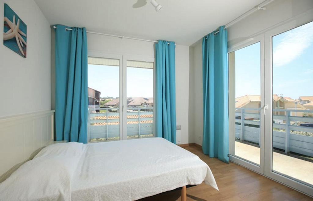 ein Schlafzimmer mit einem Bett und einem großen Fenster in der Unterkunft Résidence Indigo II - Ocean Plage Résidences in Biscarrosse-Plage