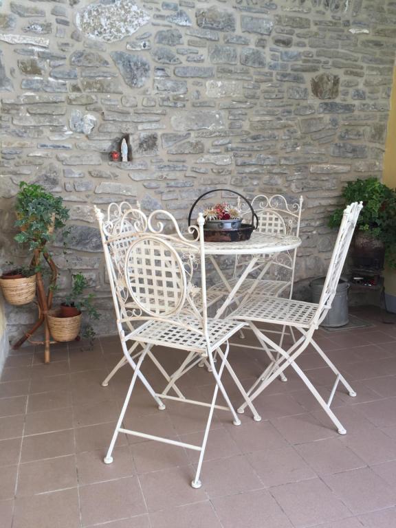 a table and two chairs sitting next to a stone wall at La casa di Marty B&B in Berceto