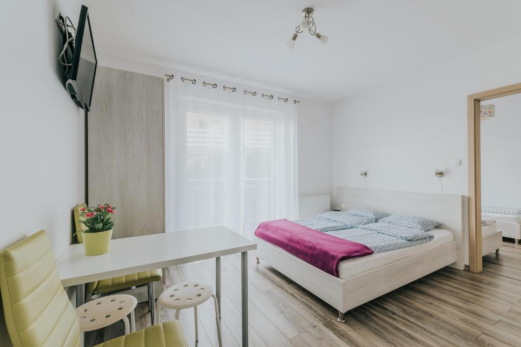 a bedroom with a bed and a table and chairs at Chatka Morska 2 in Karwia
