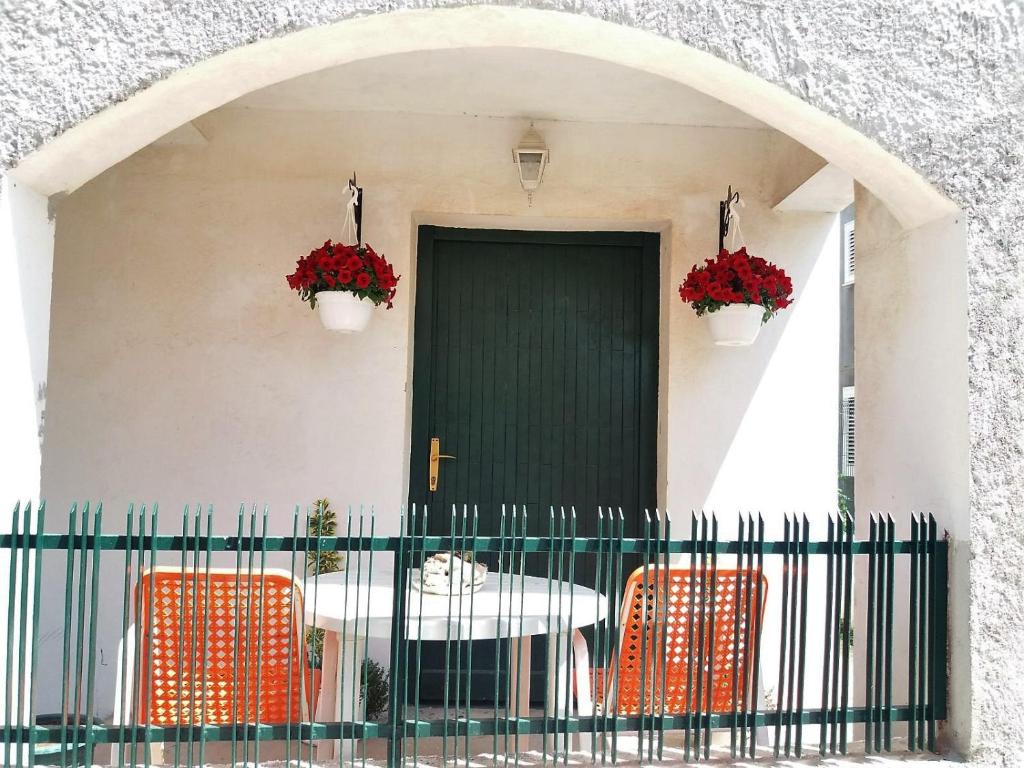 a table and chairs in front of a house with a green door at Marty Apartment in Rogoznica