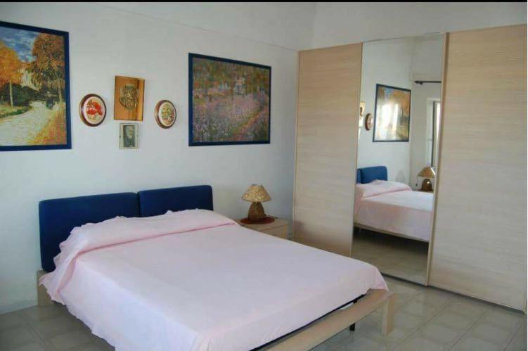 a bedroom with a large white bed and a mirror at Ponza Le Forna in Ponza