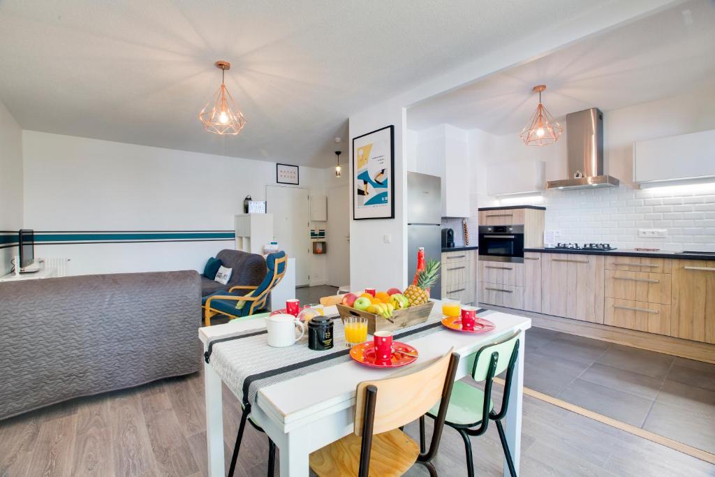 een keuken en een woonkamer met een tafel en stoelen bij Welkeys - Rue Michelet Apartment in Biarritz