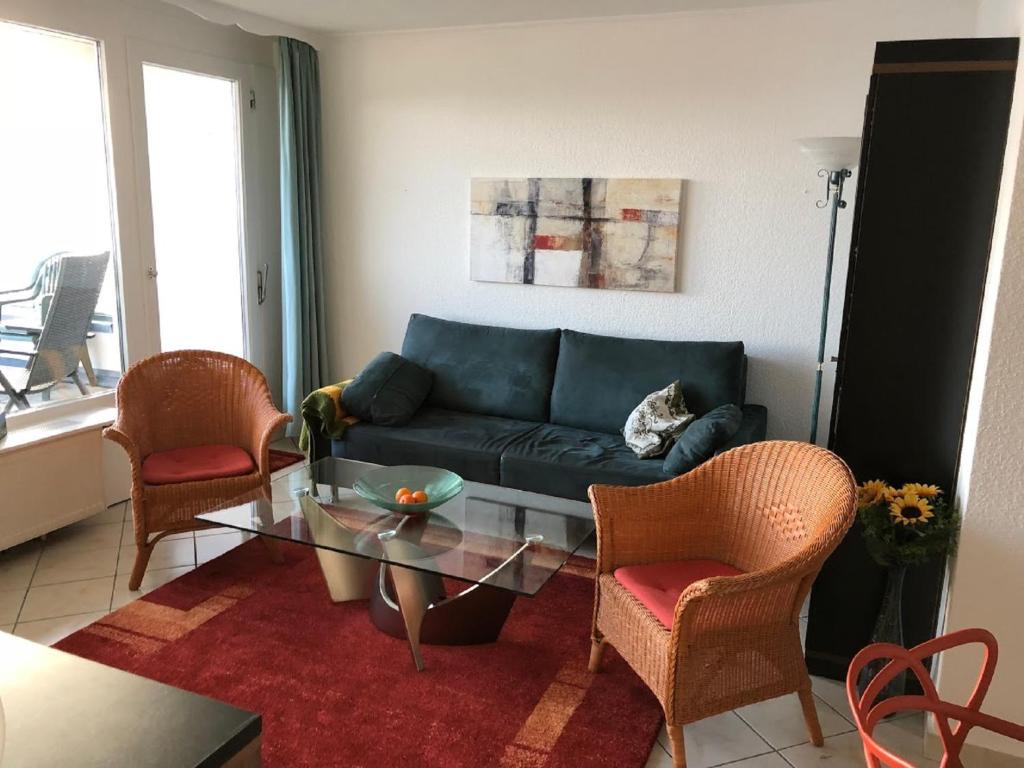 uma sala de estar com um sofá e uma mesa de vidro em Rosenalm Penthouse 147 em Scheidegg