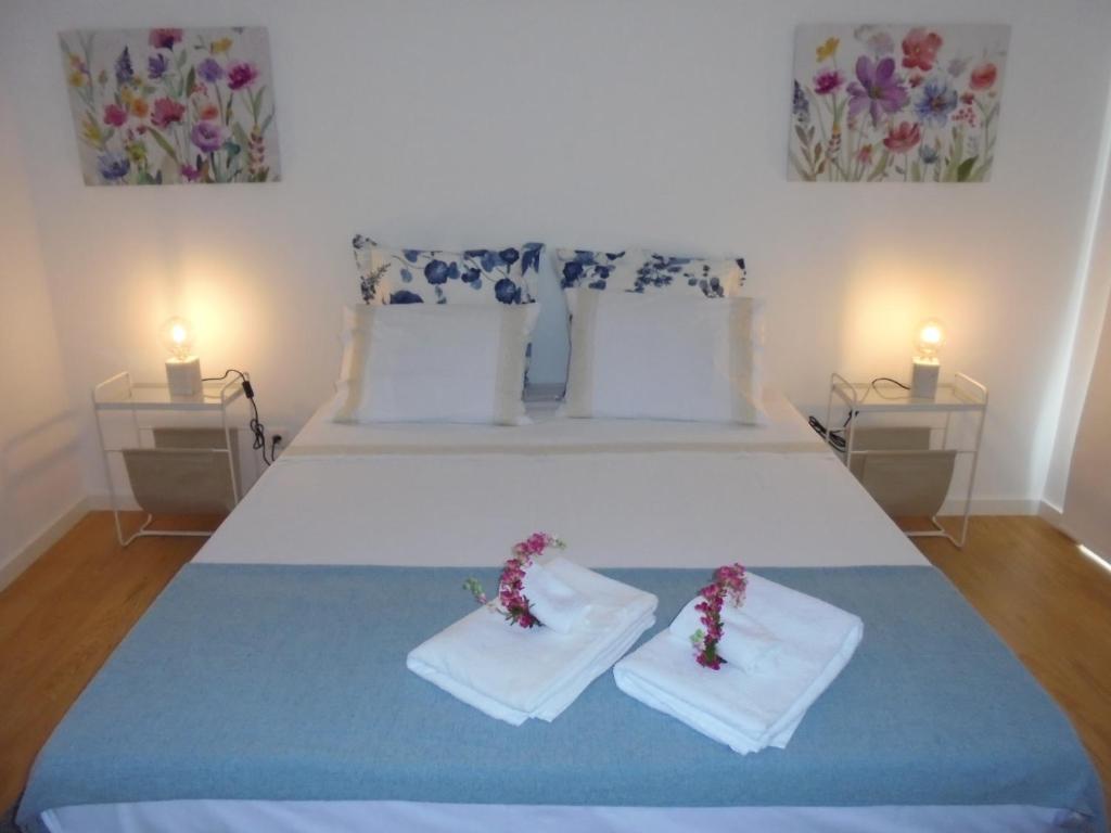 ポンタ・デルガダにあるCasa da Florのベッドルーム1室(大きな白いベッド1台、キャンドル2本付)