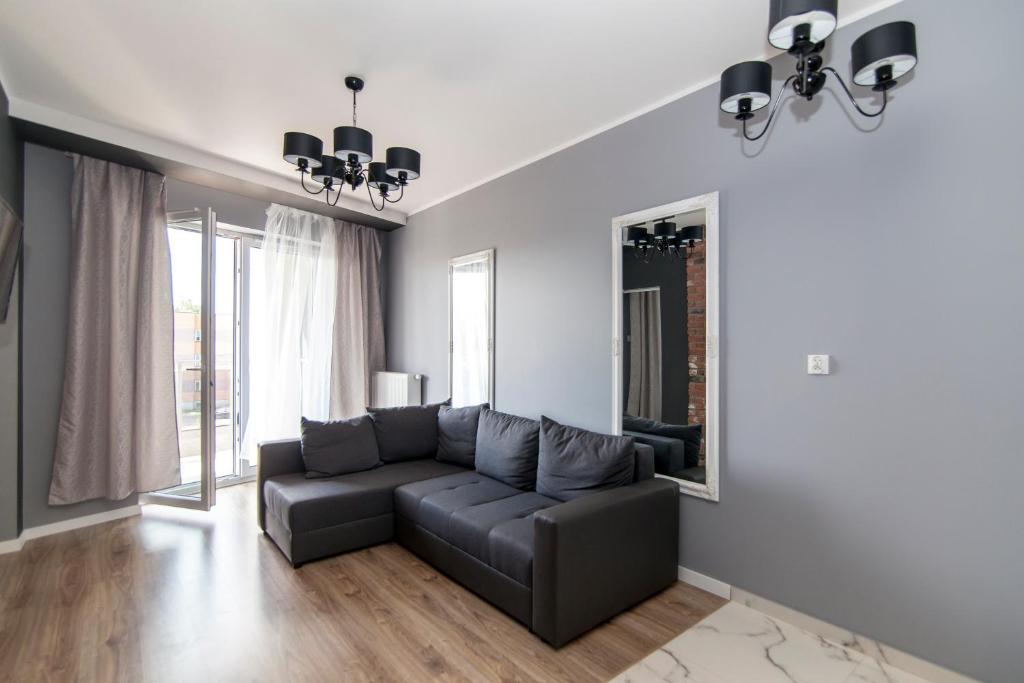 ein Wohnzimmer mit einem Sofa und einem Spiegel in der Unterkunft Apartment Royal VII in Białystok