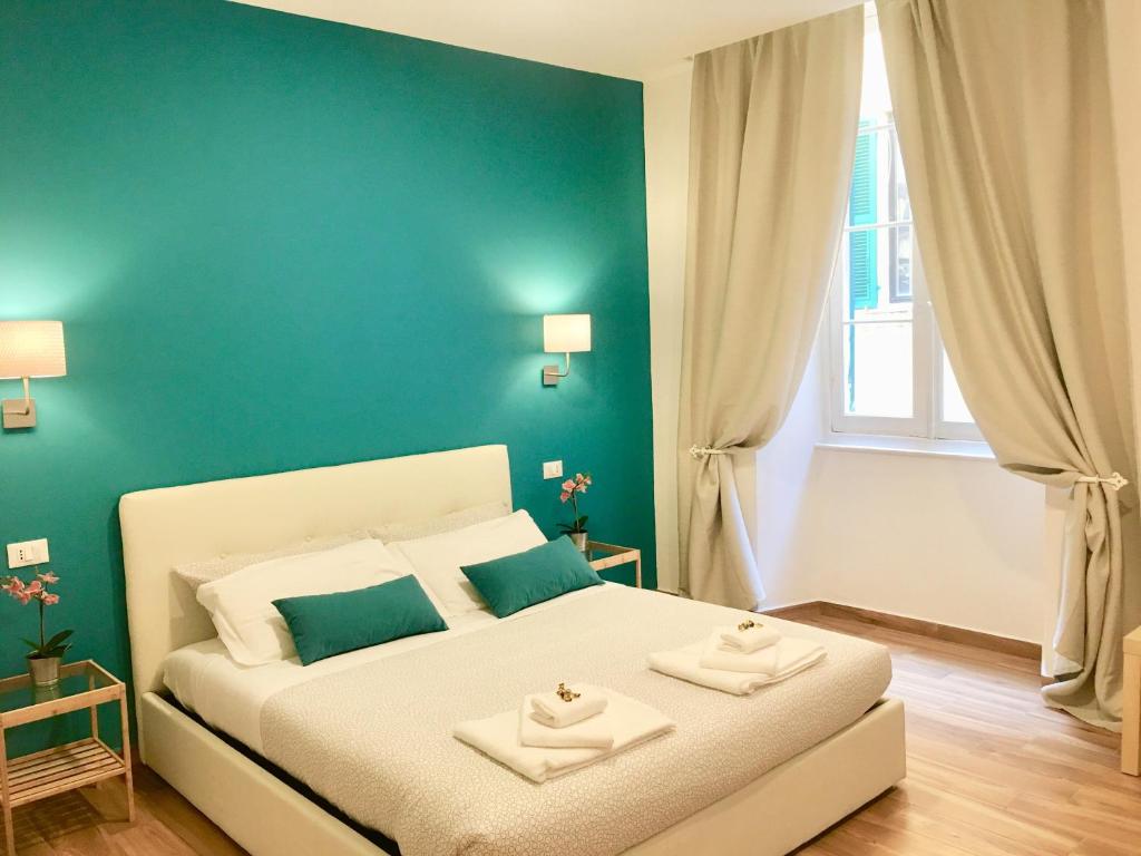 una camera da letto con un letto bianco e pareti blu di Cavallotti 21 a La Spezia