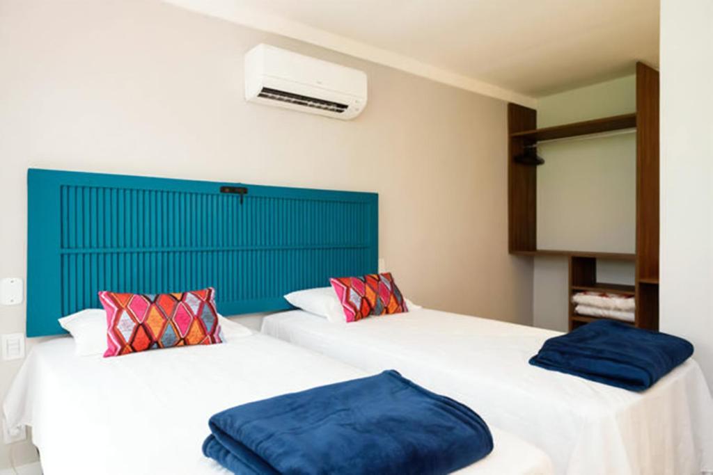 una camera con due letti con cuscini blu sopra di Icaraí Suítes a Niterói