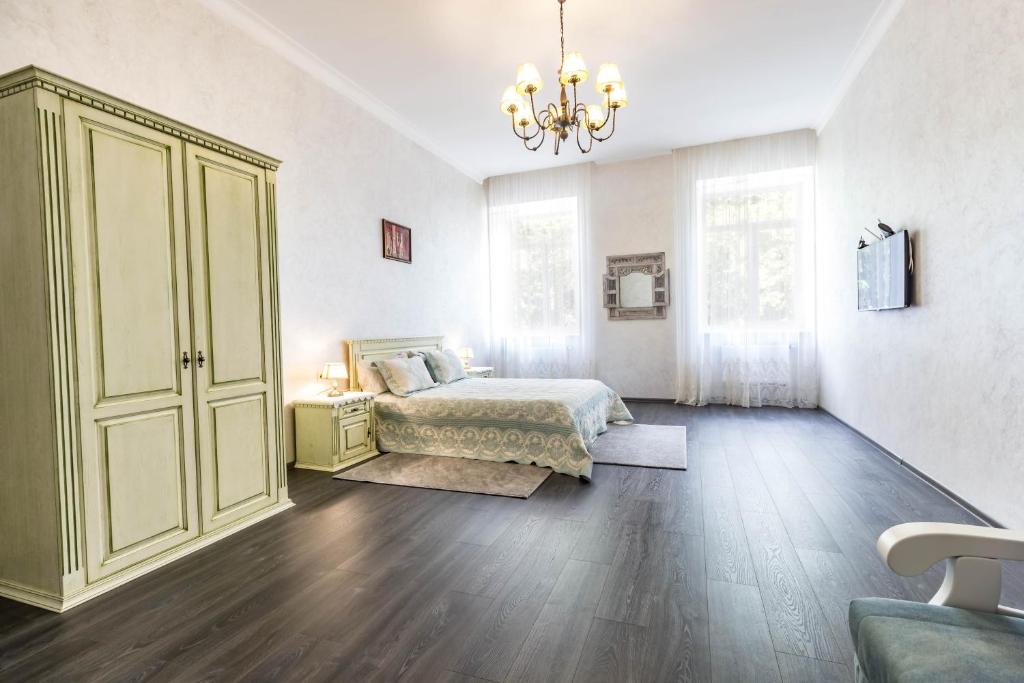 ein Schlafzimmer mit einem Bett und einem Kronleuchter in der Unterkunft Dominicana l Apartments l Lviv Historical City Center in Lwiw
