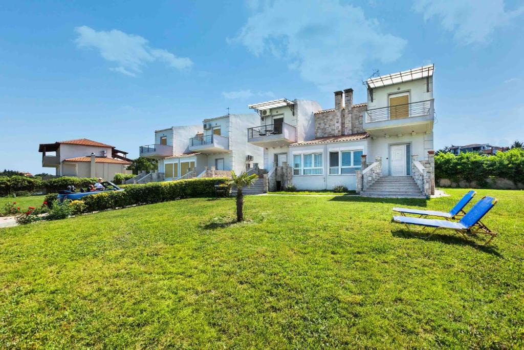 ein großes Haus mit einer blauen Bank im Hof in der Unterkunft Summer Houses in Afytos in Afytos