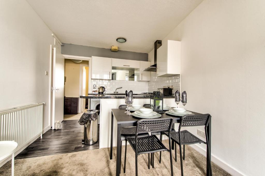 a kitchen with a table and chairs in a room at No.5 Serviced Apartment in Glasgow