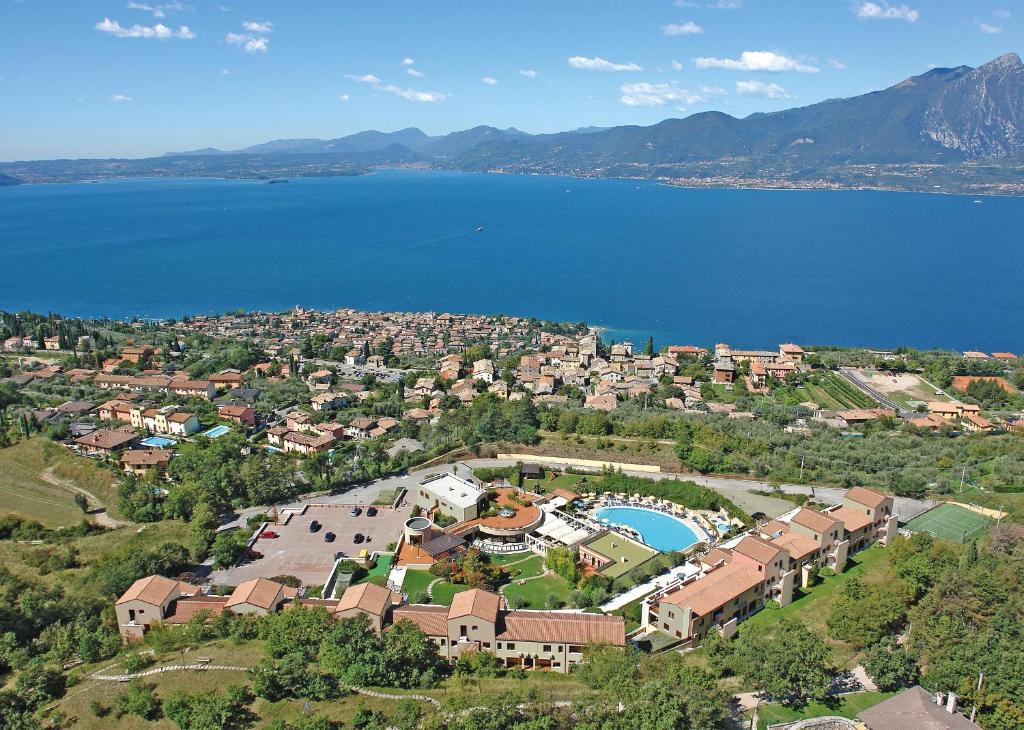 eine Luftansicht eines Resorts in der Nähe eines Wasserkörpers in der Unterkunft Le Torri Del Garda FamilySPA Resort in Torri del Benaco