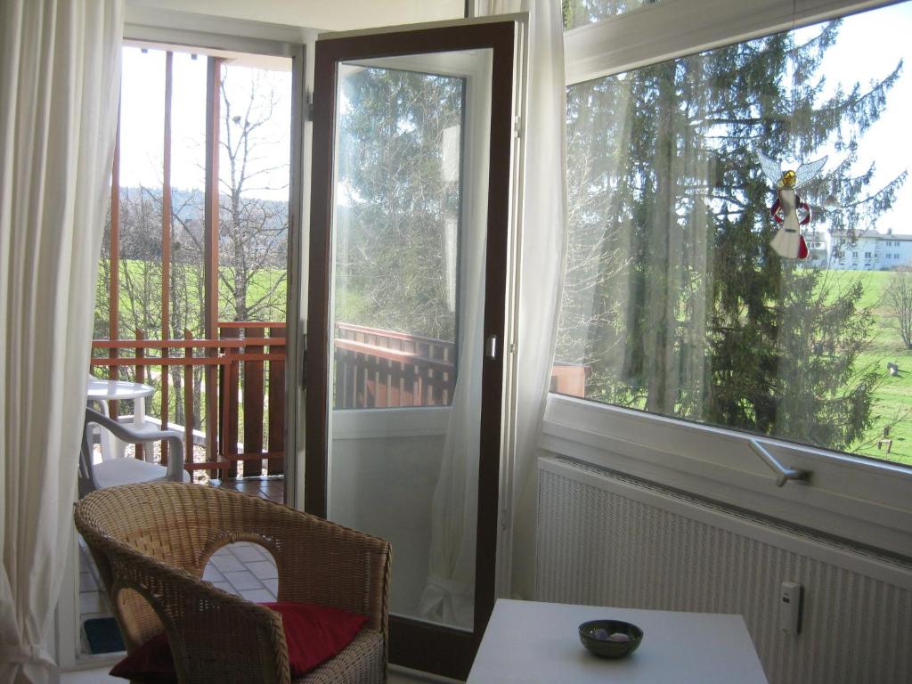 um alpendre com uma mesa e uma janela em Koenigs Appartement mit Pool em Schluchsee