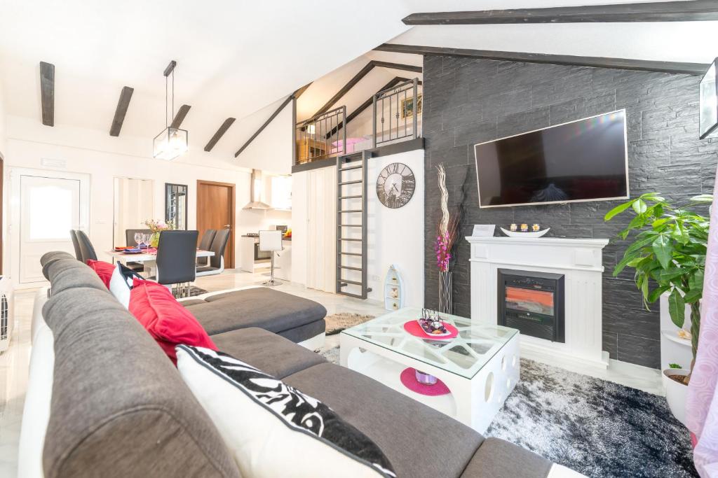 ein Wohnzimmer mit Couch und Kamin in der Unterkunft Tranquility and Nature in 4 Bedroom with Sea View in Mokošica
