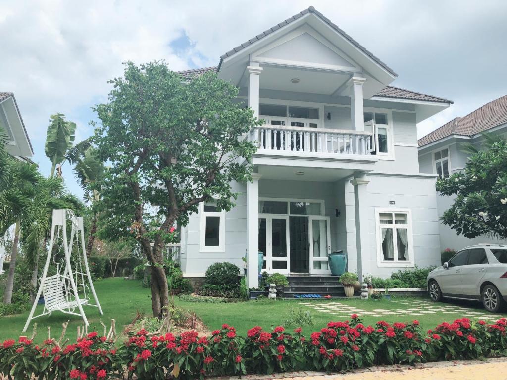 a white house with a white deck and a yard at LuxSea Villa in Phan Thiet