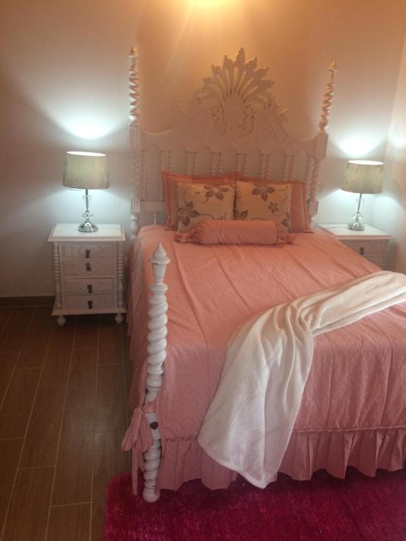a bedroom with a pink bed with two night stands at Outeiro House in Ponte de Lima
