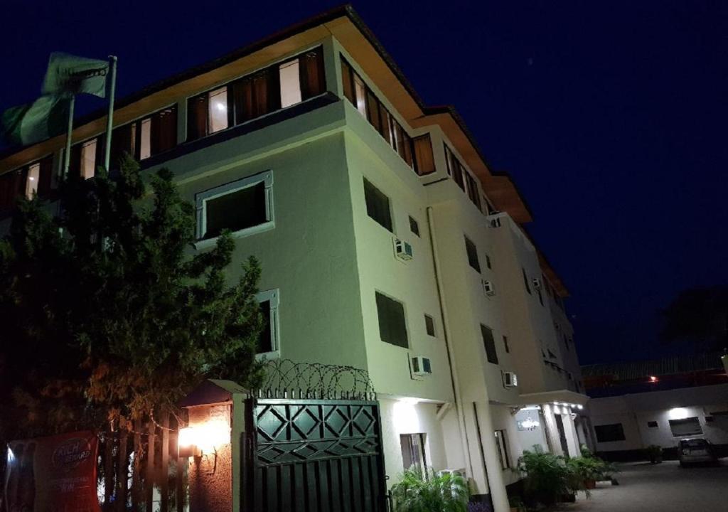 a large building with a fence in front of it at night at Citilodge Hotel & Conference Centre Newly Renovated in Abuja